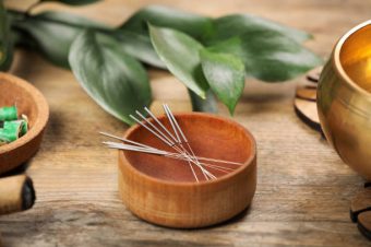 Bowl with acupuncture needles on wooden table Bowl with acupuncture needles on wooden table